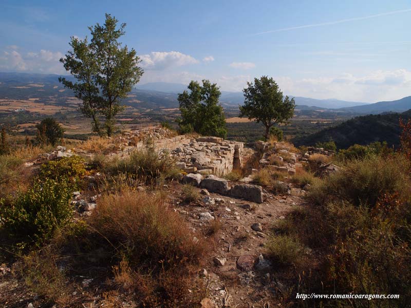 CORRALES BAJO LA PEA. AL FONDO, EL TEMPLO